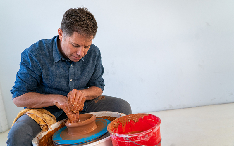 Brian smiling and holding a piece of pottery